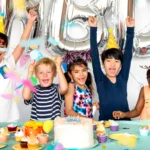 Children celebrating a birthday party with colorful decorations and a table full of treats